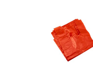 Bir yığın parlak turuncu plastik alışveriş torbası içeren yakın çekim. Çantalar düzgünce katlanmış ve düzenlenmiş, şekillerini ve dokularını gösteriyor. Canlı renkleri vurgulayan el değmemiş beyaz bir zemin üzerine kurulurlar. Resim bir ileti iletir