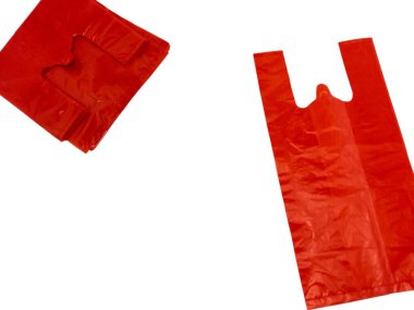 Beyaz arka planda iki kırmızı plastik poşet gösteriliyor. Torbalardan biri katlanmış ve diğeri de açık, sapı görünür durumda. Poşetler parlak, kırışık plastikten yapılmış. Görüntü iyi aydınlatılmış, basit bir kompozisyonu var..