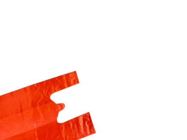 Beyaz arka planda izole edilmiş parlak turuncu plastik bir alışveriş çantasının yakın çekimi. Çanta çapraz konumda, saplarını ve desenli yüzeyini gösteriyor. Resim renk karşıtlığını ve kompozisyonun basitliğini vurgular.