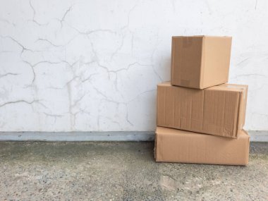 Üç karton kutu desenli beyaz bir duvara karşı sergileniyor. Bu da hareket ya da nakliye senaryosunu akla getiriyor. Kutular beton bir zemine yerleştirilmiş, bir depoya ya da yükleme alanına işaret ediyorlar. Görüntünün tarafsız bir tonu var ve odak noktası...