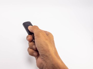 Siyah bir arabanın uzaktan kumandasını beyaz arka planda tutan bir elin yakın çekimi. El odak noktasında, deri dokusunun ayrıntıları görünür durumda. Kompozisyon basit, uzaktan kumandanın anahtar ögesini vurguluyor.