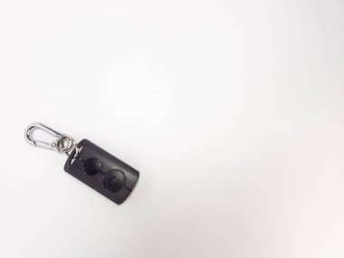 Üzerinde iki düğme ve bir şarjör olan siyah bir anahtarlığın yakın çekim çekimi. Anahtarlık temiz beyaz bir arkaplan üzerine yerleştirilmiş, parlak tasarımı ve işlevselliğini vurguluyor. Güvenliği, erişimi, ya da