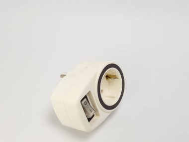 Beyaz arka planda güç düğmesi olan beyaz bir elektrik prizinin izole edilmiş görüntüsü. Priz açılı, tıkaç çatallarını ve prizi gösteriyor. Düğme 