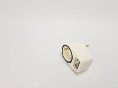 Beyaz bir elektrik adaptörünün temiz beyaz bir arkaplanla izole edilmiş yakın plan görüntüsü. Adaptör çapraz konumda, tasarımını gösteriyor. Görüntü iyi ışıklandırılmış ve basit, minimalist bir estetiğe sahip, vario için uygun.