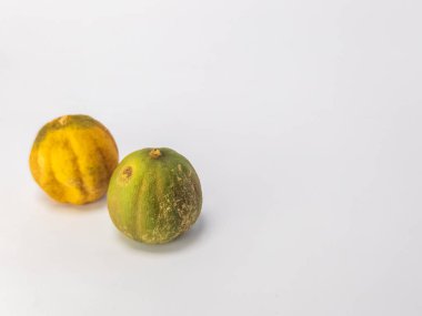İki kurutulmuş limon, temiz beyaz bir arka planda izole edilir. Bir kireç çoğunlukla yeşil ve diğeri kahverengi işaretli sarı. Fotoğraf bir stüdyo ortamında çekiliyor, metin veya diğer tasarım elemanları için yeterli kopya alanı sunuluyor.