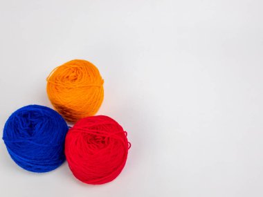 Birincil renklerde üç iplik yumağından oluşan bir stüdyo çekimi: mavi, kırmızı ve sarı-turuncu. Toplar düz beyaz arkaplana karşı üçgen bir kompozisyonda düzenlenir, temiz ve basit bir estetik sağlar. Bu resim resimleme için mükemmeldir 