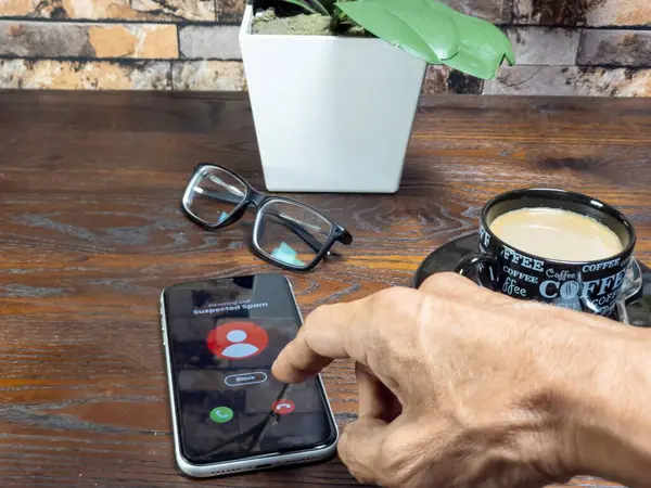 Gelen e-posta uyarısını gösteren akıllı telefonu tutan bir el. Telefon ekranında kırmızı alarm simgesiyle 