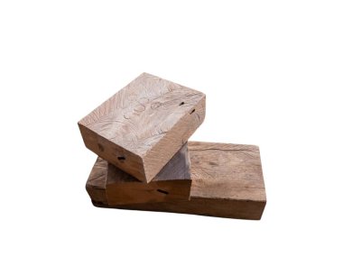 İki yıpranmış tahta blok üst üste beyaz bir zemine karşı istiflenmiş, doğal ahşap tanecikleri ve dokuları sergiliyorlar. Bloklar eski ve kırsal görünüyor. İnşaat ve tasarım alanında kullanıldıklarını gösteriyor..