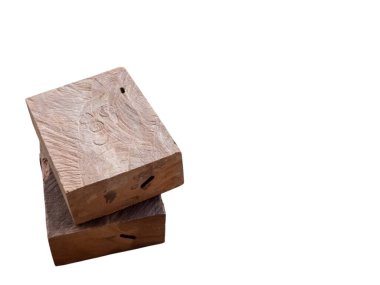 İki dikdörtgen tahta blok bir açıyla istiflenmiş. Bloklar yıpranmış ve tahtanın doğal yapısını gösteriyor. Görüntü, blokların dokusunu ve biçimini vurgulayan temiz beyaz bir arkaplana karşı çekilir.. 