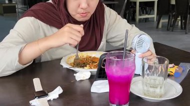 Restoran masasında Tazeleyici İçecekle Yemek Yiyen Kadın.