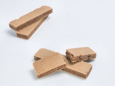 Bu stüdyo çekiminde parlak beyaz bir arka planda birkaç çikolatalı gofretli kurabiye ustalıkla düzenleniyor. Ekmeğin dokusuna ve katmanlarına odaklanarak, açık renkli çıtır gofretlerle siyah çikolatalar arasındaki zıtlığı vurguluyor. 