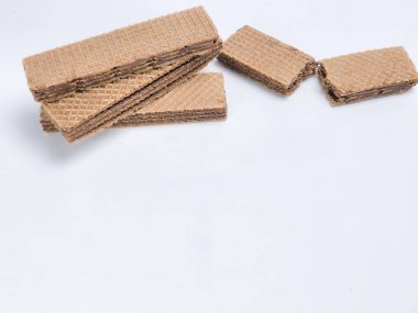 Yakın plan çekimde el değmemiş beyaz bir yüzeye yerleştirilmiş birkaç çikolatalı gofret kurabiyesi sergilenir. Kurabiyeler dikdörtgen şeklinde, desenli, gofret gibi bir görünüşü var..