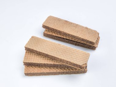 Yakın plan çekimde beyaz arka planda bir yığın çikolatalı gofret sergilenir. Gofretler dikdörtgendir, dokulu bir yüzeyi vardır. Çikolata dolgusu katmanlar arasında görünür..