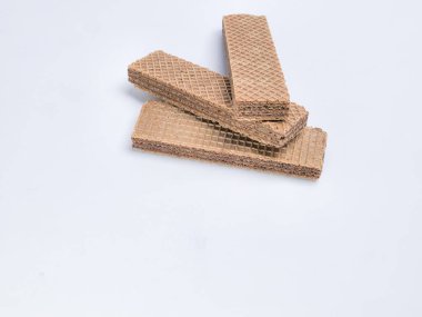 Bu stok fotoğraf düz beyaz bir arka plana ustaca yerleştirilmiş birkaç çikolatalı gofret kurabiyesi içerir. Resim, yiyeceklerin cazibesini vurgulayarak kurabiyelerin dokusunu ve lezzetli görünümünü vurguluyor. Aşçılık projeleri için mükemmel..