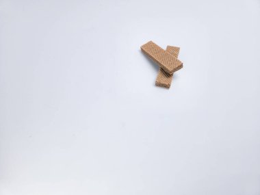 İki kıtır, dikdörtgen çikolatalı gofret kurabiyesi temiz, beyaz bir arka plana yerleştirilir. Gofretler örtüşen bir şekilde konumlandırılmışlar, desenli yüzeylerini gösteriyorlar...