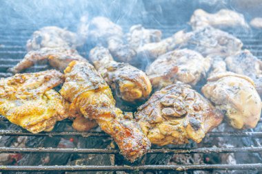 Kızgın kömürde ızgara tavuk. Açık havada duman ve ateş ile sulu, kahverengi et. Geleneksel bir yemek, aile toplantıları ve hafta sonları için mükemmel..