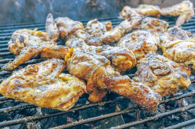 Kızgın kömürde ızgara tavuk. Açık havada duman ve ateş ile sulu, kahverengi et. Geleneksel bir yemek, aile toplantıları ve hafta sonları için mükemmel..