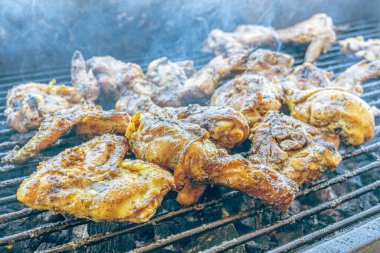 Kızgın kömürde ızgara tavuk. Açık havada duman ve ateş ile sulu, kahverengi et. Geleneksel bir yemek, aile toplantıları ve hafta sonları için mükemmel..