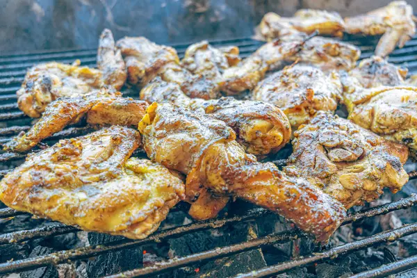 Kızgın kömürde ızgara tavuk. Açık havada duman ve ateş ile sulu, kahverengi et. Geleneksel bir yemek, aile toplantıları ve hafta sonları için mükemmel..