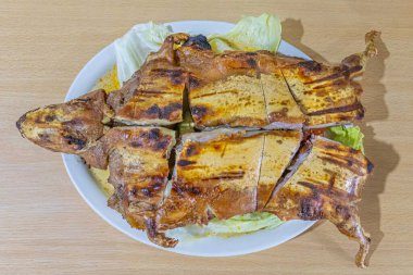 Geleneksel Hint domuzu yemeği ya da kızarmış Gine domuzu, Ekvador mutfağının zenginliğini, kültürünü ve otantik lezzetlerini vurgulayan Andean malzemeleriyle servis edilen tipik bir Ekvador yemeği..