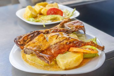 Geleneksel Hint domuzu yemeği ya da kızarmış Gine domuzu, Ekvador mutfağının zenginliğini, kültürünü ve otantik lezzetlerini vurgulayan Andean malzemeleriyle servis edilen tipik bir Ekvador yemeği..