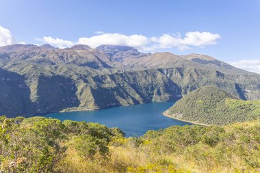 Cotacachi, Ecuador  August 5, 2025: Cuicocha Lagoon in the Ecuadorian Andes, surrounded by vegetation. In the background, the majestic Cotacachi Volcano with its summit hidden among the clouds.