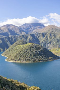 Cotacachi, Ecuador  August 5, 2025: Cuicocha Lagoon in the Ecuadorian Andes, surrounded by vegetation. In the background, the majestic Cotacachi Volcano with its summit hidden among the clouds.