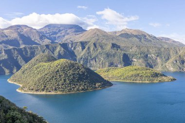 Cotacachi, Ecuador  August 5, 2025: Cuicocha Lagoon in the Ecuadorian Andes, surrounded by vegetation. In the background, the majestic Cotacachi Volcano with its summit hidden among the clouds.