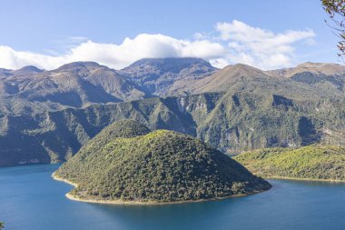 Cotacachi, Ecuador  August 5, 2025: Cuicocha Lagoon in the Ecuadorian Andes, surrounded by vegetation. In the background, the majestic Cotacachi Volcano with its summit hidden among the clouds.