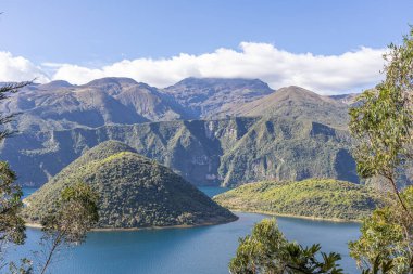 Cotacachi, Ecuador  August 5, 2025: Cuicocha Lagoon in the Ecuadorian Andes, surrounded by vegetation. In the background, the majestic Cotacachi Volcano with its summit hidden among the clouds.
