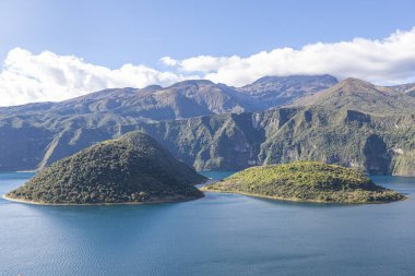 Cotacachi, Ecuador  August 5, 2025: Cuicocha Lagoon in the Ecuadorian Andes, surrounded by vegetation. In the background, the majestic Cotacachi Volcano with its summit hidden among the clouds.