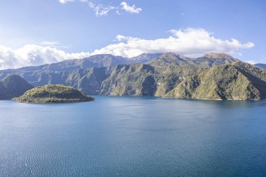 Stunning view of Cuicocha Lagoon with the Cotacachi Volcano in the background, its peak hidden among the clouds. A naturally beautiful Andean landscape in Ecuador.