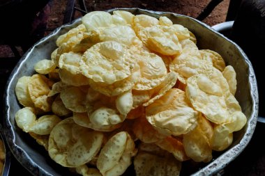 Geleneksel bir kasede sunulan ve çıtır çıtır dokuları yakalayan yeni hazırlanmış altın papatyaların detaylı bir görüntüsü. Hakiki mutfağın ve sokak yemekleri hazırlıklarının mükemmel tasviri..