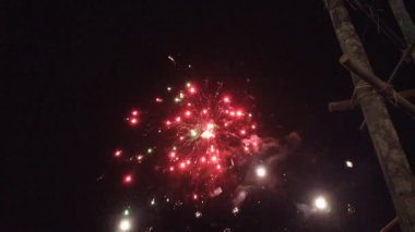 Karanlık gece gökyüzünde parıldayan renkli havai fişekler, canlı bir kutlama ve şenlik gösterisi yaratıyor. Bayram teması için mükemmel, yeni yıl arifesi, ya da keyifli durumlar için.