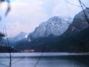 Karla kaplı zirveler sakin bir gölün yanında görkemli bir şekilde yükselirler. Kenarına kurulmuş büyüleyici bir tatil köyü, resimli bir manzarada kışın dingin güzelliğini gözler önüne serer..