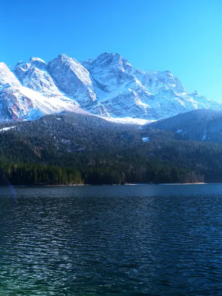 Bereketli bir gölün üzerinde yükselen karla kaplı zirveler, yemyeşil ormanlarla çevrili, güneşli bir günde güzellikleri gözler önüne seriyor..
