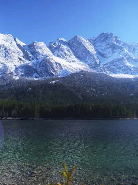 Kristal berrak su, güneş tepemizde ışıl ışıl parlarken görkemli kar örtülü dağları yansıtıyor ve vahşi doğada sakin bir kış atmosferi sergiliyor..