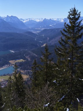 Yüksek bir bakış açısından nefes kesici manzara görkemli dağları, yemyeşil vadileri ve parlak mavi gökyüzünün altındaki dingin gölleri gözler önüne serer..