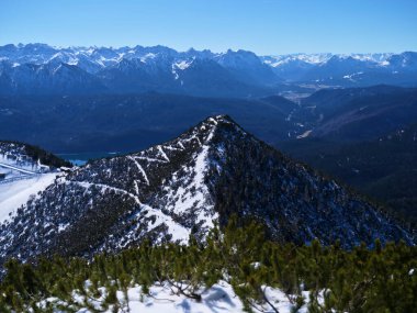 Karla kaplı dağlar parlak mavi gökyüzüne çarpıcı bir şekilde yükselir. Sahne engebeli tepeler ve sakin vadiler sergiliyordu. Nefes kesici bir kış manzarası yaratıyordu..
