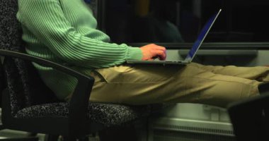 Bir insan trende rahatça otururken dizüstü bilgisayarına odaklanır. İçerisi loş bir şekilde aydınlatılmış. Seyahat sırasında üretkenlik için mükemmel bir atmosfer yaratıyor..