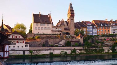 Büyüleyici mimari, günbatımında bu huzurlu kasabanın nehir kıyısında, suyun üzerinde canlı renkler yansıtan, tarihin ve manzaranın bir karışımını sergiliyor..