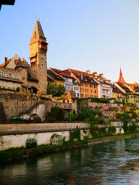 Tarihsel binalar nehir kıyısında güneş batarken göze çarpan görkemli bir kuleyle kentin huzurlu sularına sıcak bir ışıltı saçıyor..