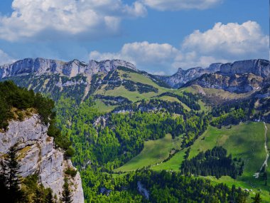 Uçsuz bucaksız dağ sıraları ufuk boyunca uzanır, yemyeşil vadileri kaplar..