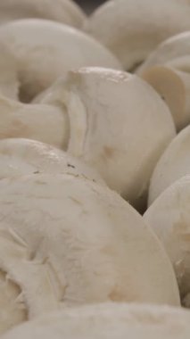 Mutfakta taze mantarların yakın çekimleri pürüzsüz yüzeylerini ve doğal renklerini gözler önüne seriyor. Çeşitli yemekler için mükemmel malzemeler, lezzet ve besin artışı.