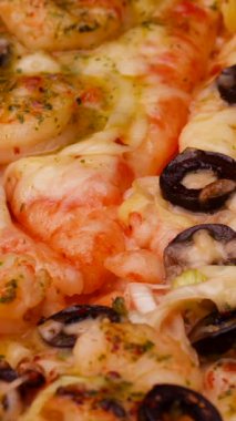 Sıcak bir mutfakta taze karides ve dilimlenmiş zeytin sergilenen enfes bir aşçılık gösterisi. Canlı bileşenler birleşerek lezzetli bir yemek oluşturur..