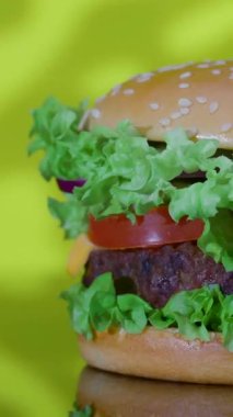 Canlı bir hamburger, taze marul katmanları, sulu domates ve mükemmel pişirilmiş bir köfte içerir. Hepsi susamlı bir çöreğin üzerine kuruludur..