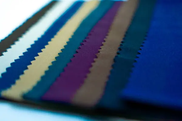 Canlı bir kumaş örneği koleksiyonu, beyaz arka planda parlak renkler ve desenler sergiliyor. Sıradan moda ve tekstil tasarımı için harika..
