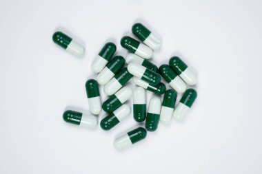 Besin ve Vitamin içeren kapsüller, beyaz arka planda beyaz veya yeşil kapsüller, Enerji ve Yaşam İçin Vitamin zengini Kapsüller
