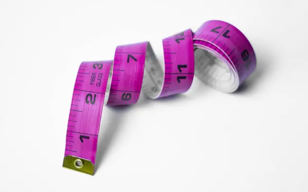 Yüksek kaliteli bir mezura fotoğrafı. Beyaz arka planda hem santimetre hem de santimetre şeklinde izler var. Uluslararası projeler ve eğitim içeriği için harika.