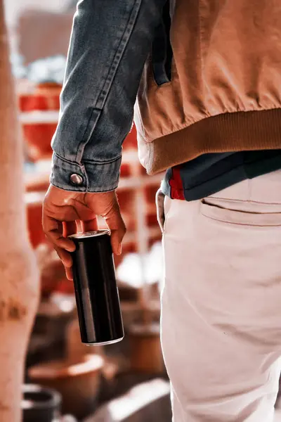 Enerji içeceği taşıyan çocuk mavi pantolon giyiyor.               